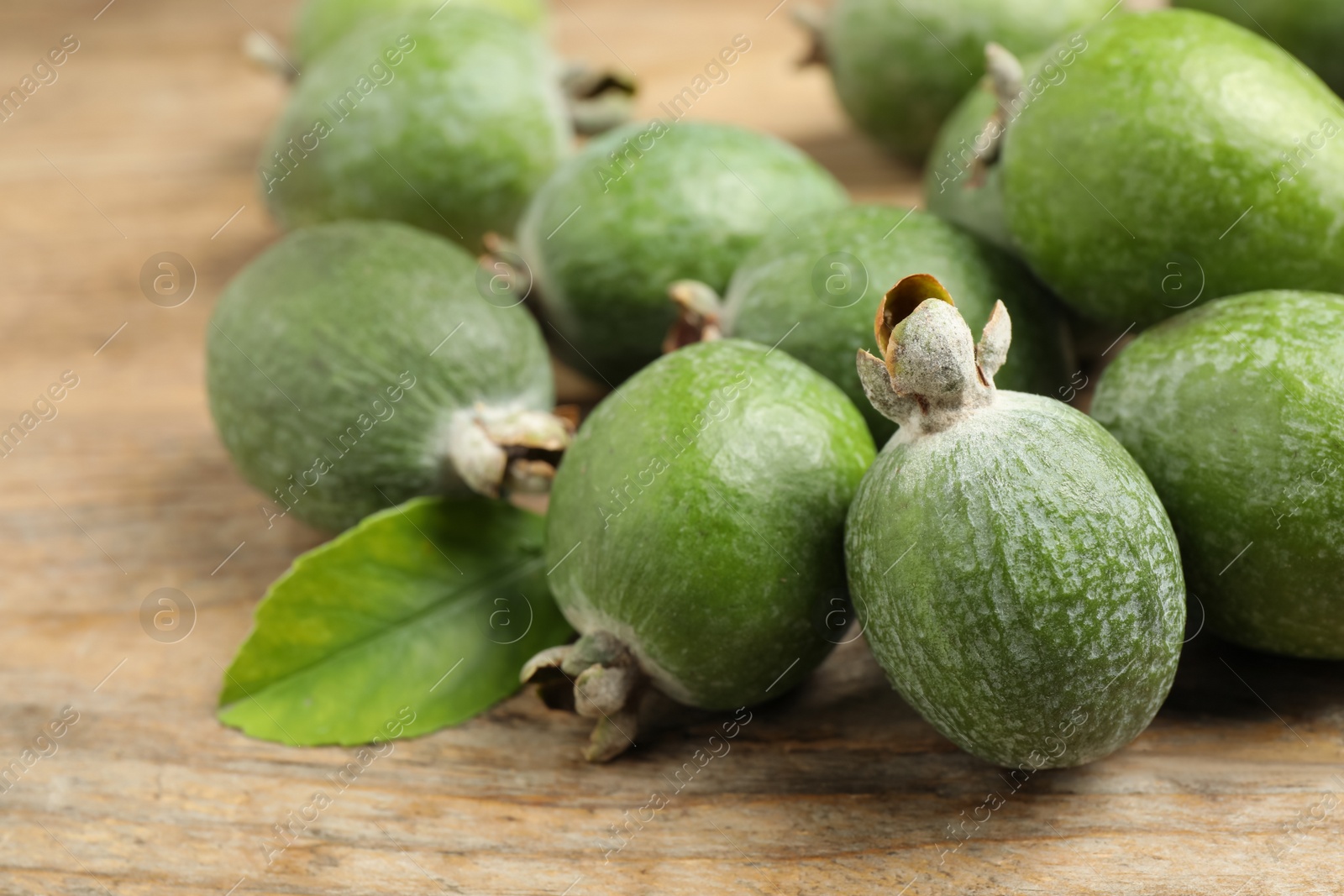 Photo of Fresh green feijoa fruits on wooden table, closeup