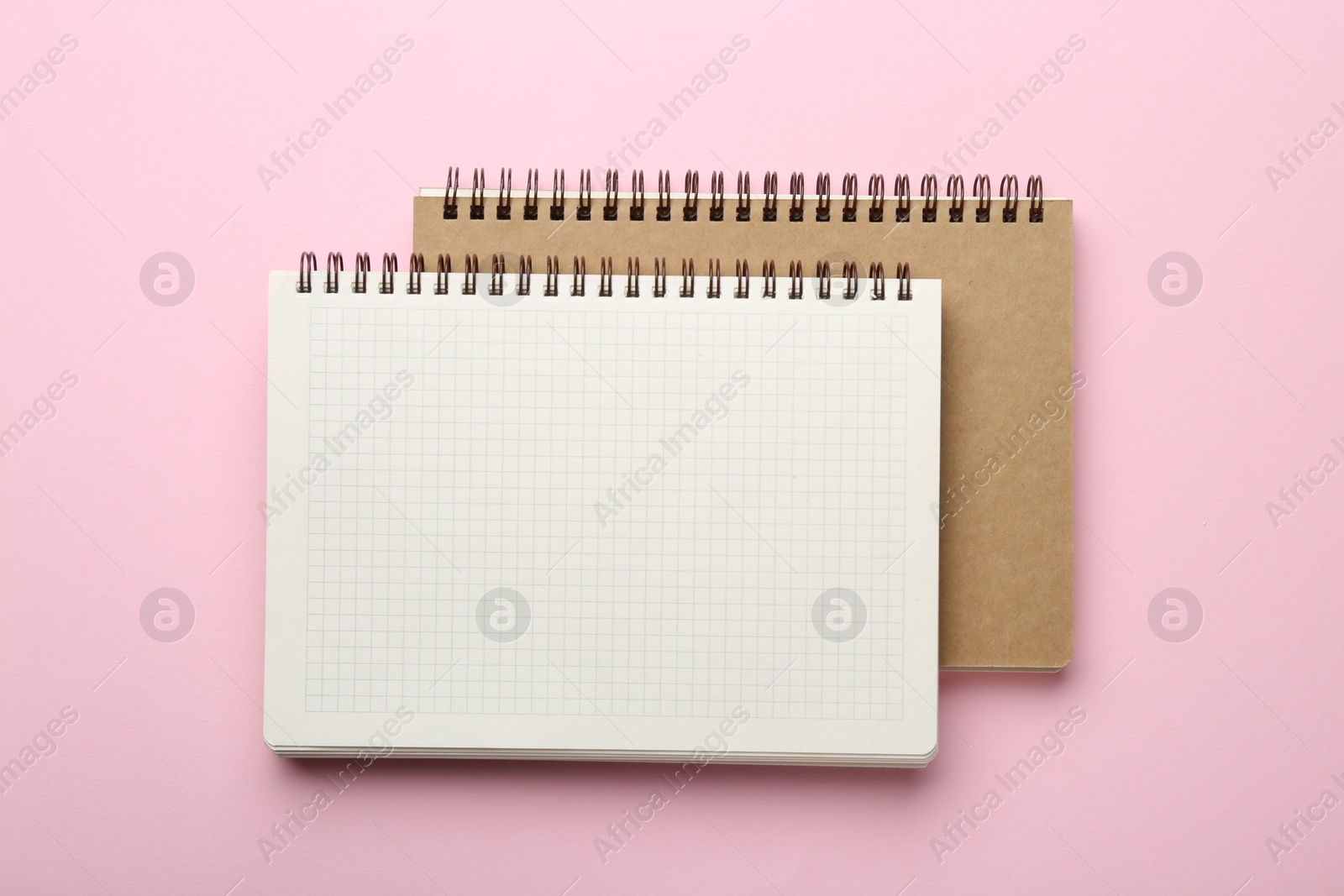 Photo of Two notebooks on pink background, top view