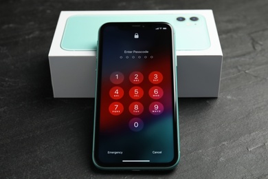 Photo of MYKOLAIV, UKRAINE - JULY 10, 2020: New modern Iphone 11 with numpad for entering passcode near box