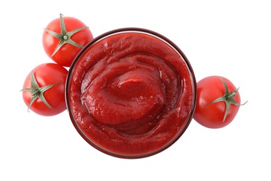 Tasty ketchup in glass bowl and fresh tomatoes isolated on white, top view