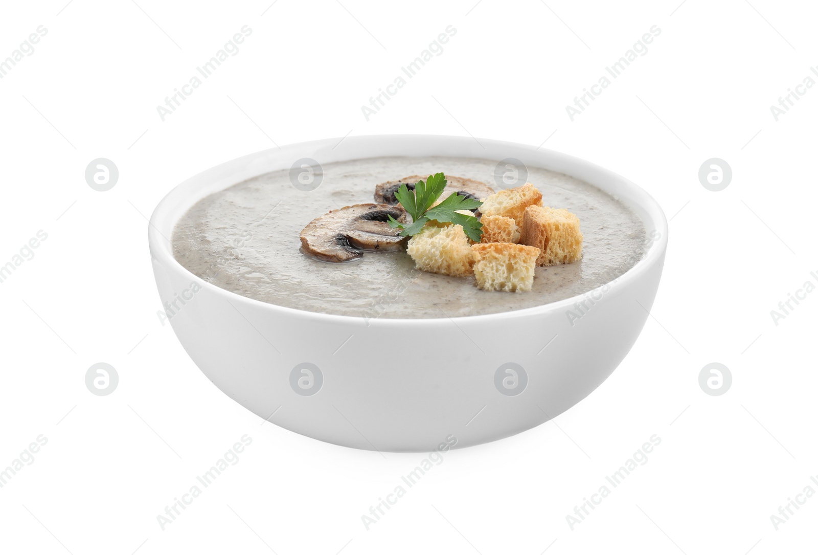 Photo of Delicious mushroom cream soup with croutons in bowl isolated on white