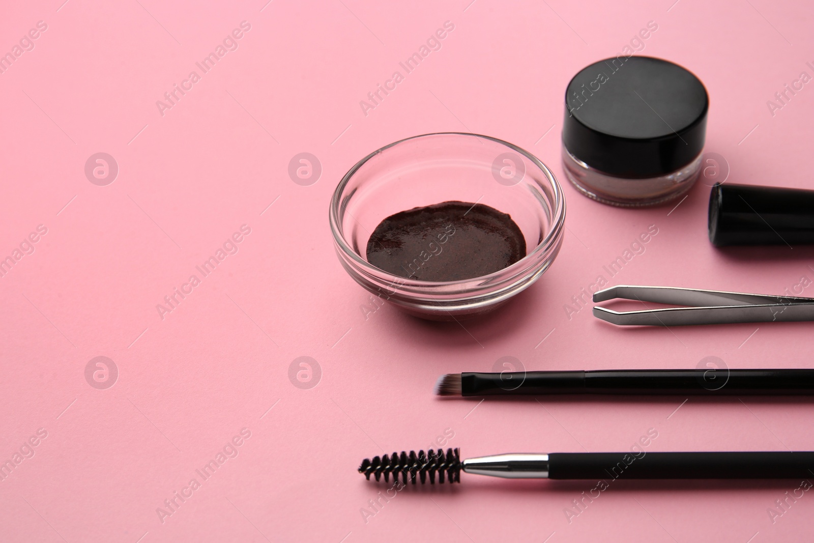 Photo of Eyebrow henna and professional tools on pink background, space for text