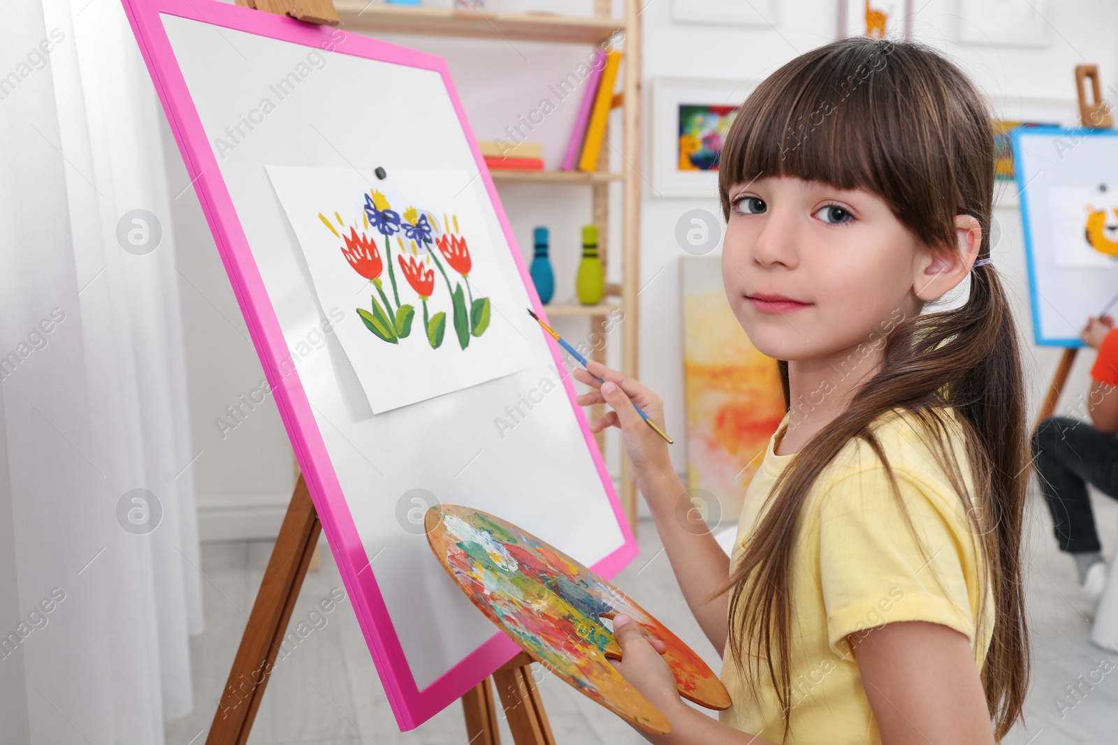 Photo of Cute little child painting during lesson in room