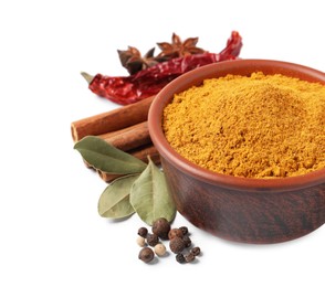 Curry powder in bowl and other spices isolated on white