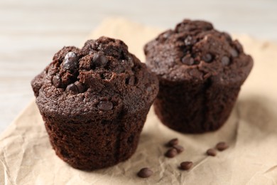 Delicious chocolate muffins on light table, closeup