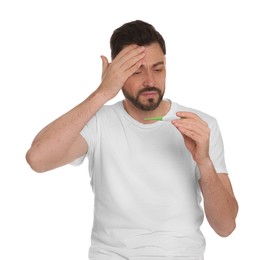 Man with rash holding thermometer on white background. Monkeypox virus diagnosis