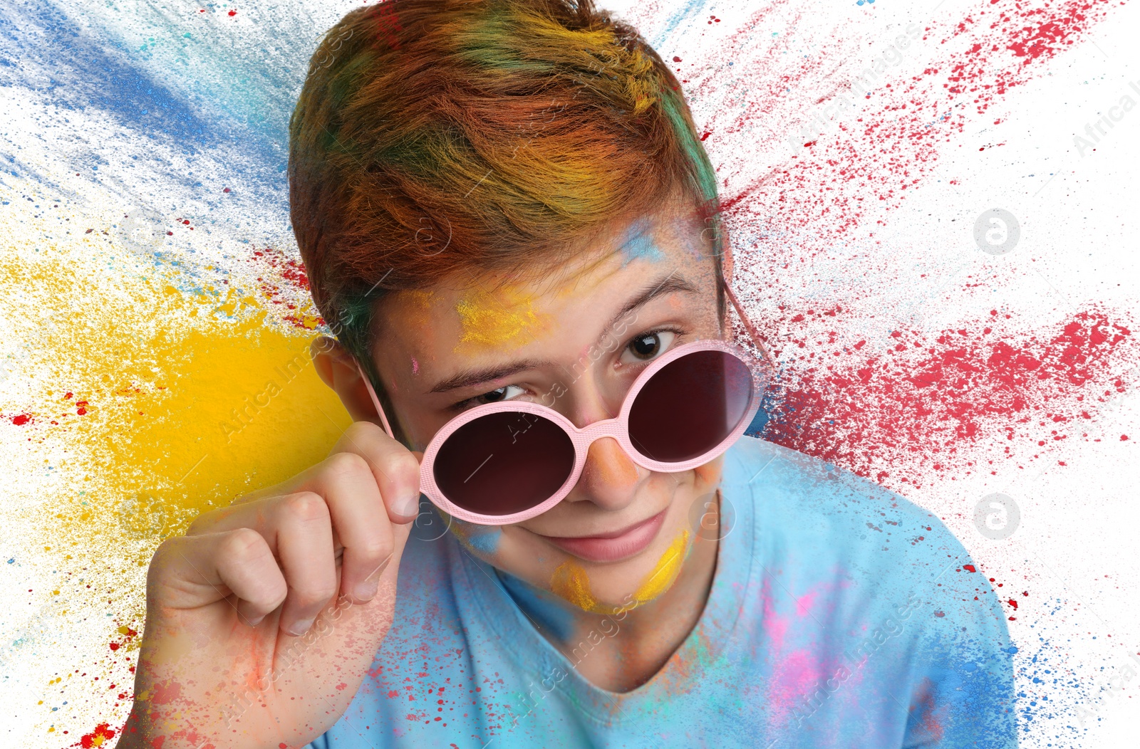 Image of Holi festival celebration. Teen boy covered with colorful powder dyes on white background