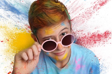 Holi festival celebration. Teen boy covered with colorful powder dyes on white background