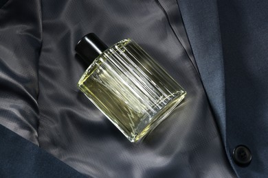 Luxury men's perfume in bottle on grey jacket, above view