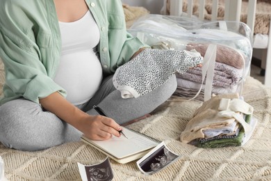 Photo of Pregnant woman preparing list of necessary items to bring into maternity hospital on bed at home, closeup