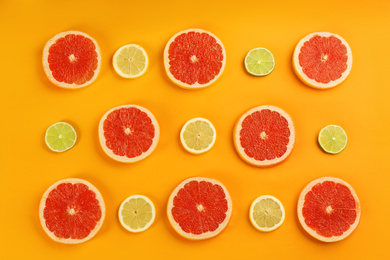 Photo of Flat lay composition with tasty ripe grapefruit slices on orange background