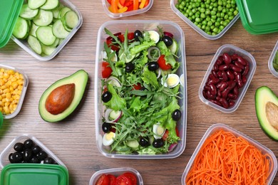 Set of plastic containers with fresh food on wooden  table, flat lay