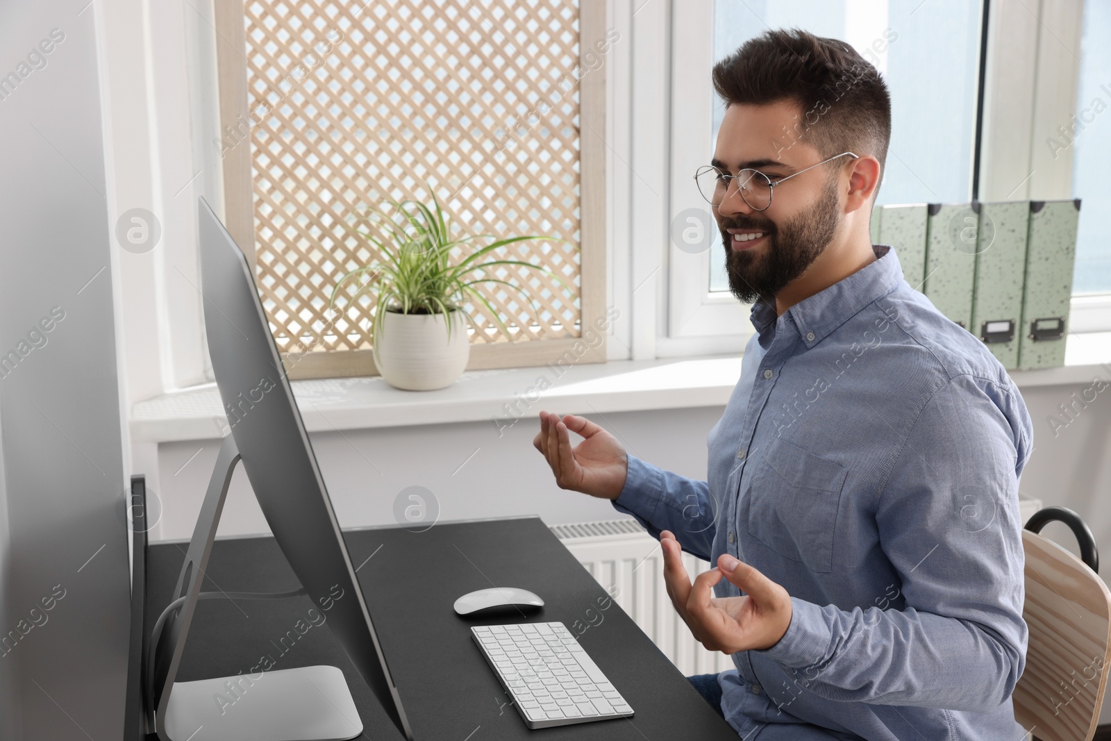 Photo of Young businessman meditating at workplace. Zen concept