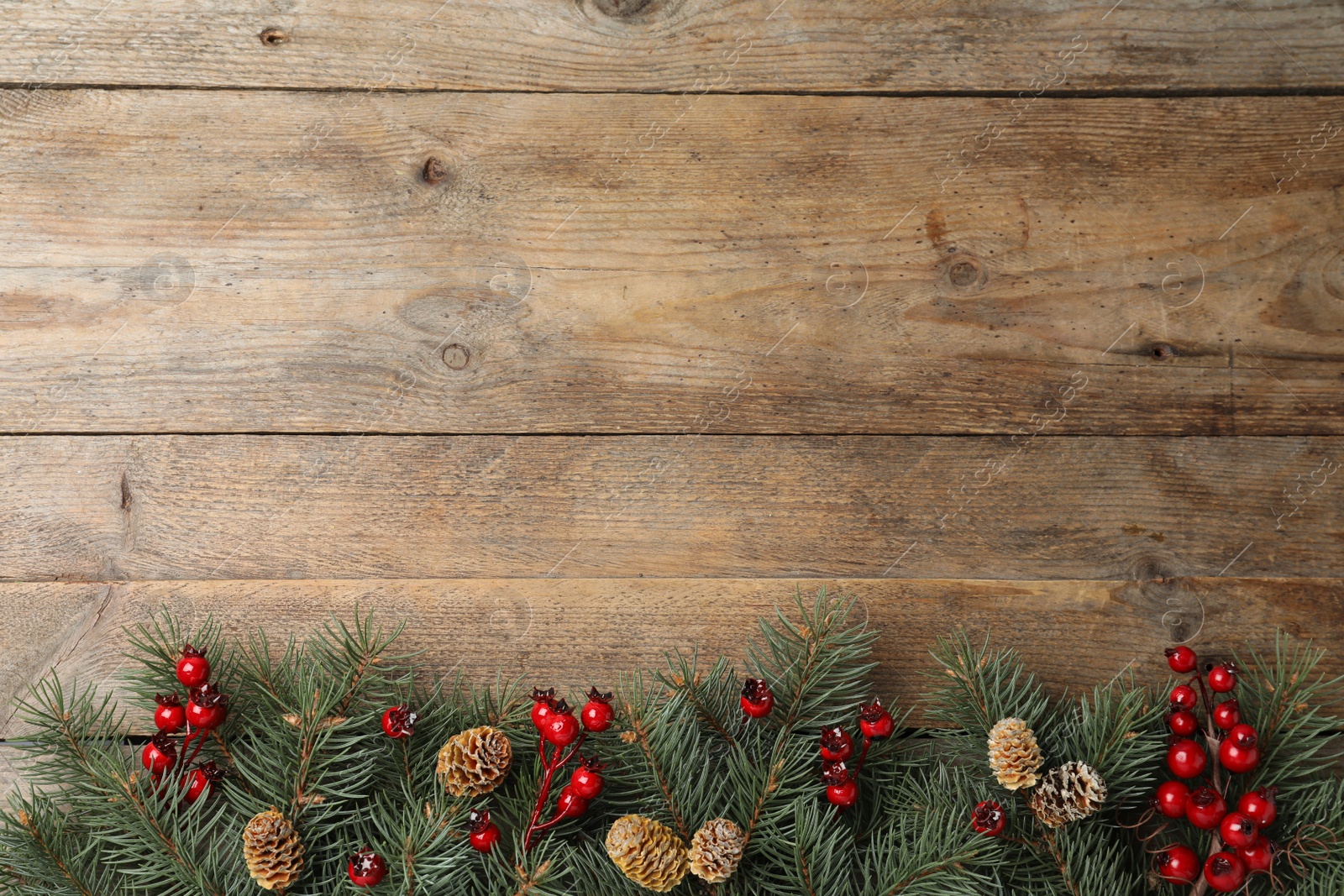 Photo of Flat lay composition with fir branches and berries on wooden background, space for text. Winter holidays