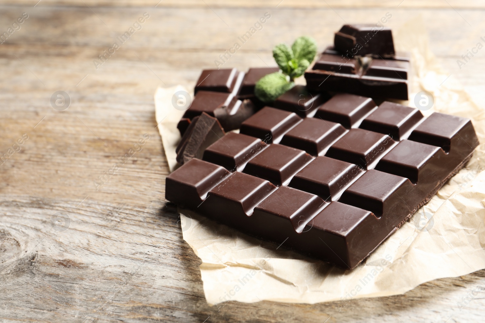 Photo of Tasty chocolate on wooden background. Space for text