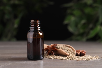 Photo of Anise essential oil and spice on table