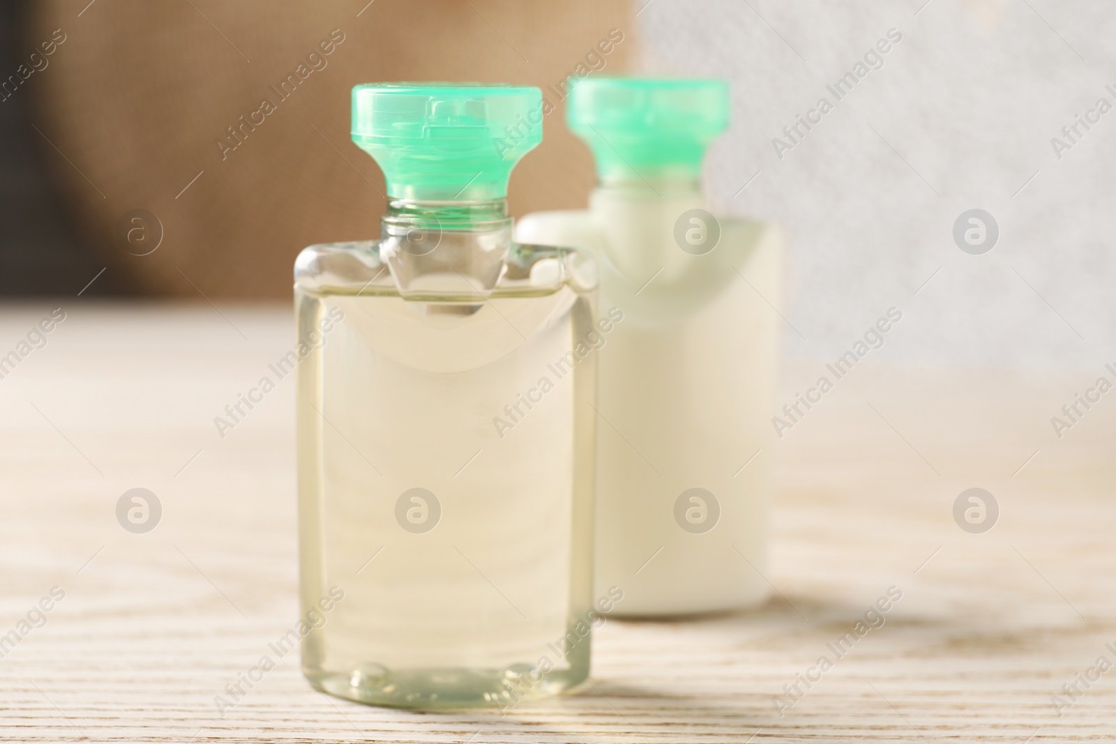 Photo of Mini bottles of cosmetic products on white wooden table