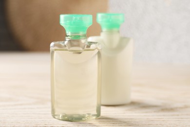 Photo of Mini bottles of cosmetic products on white wooden table