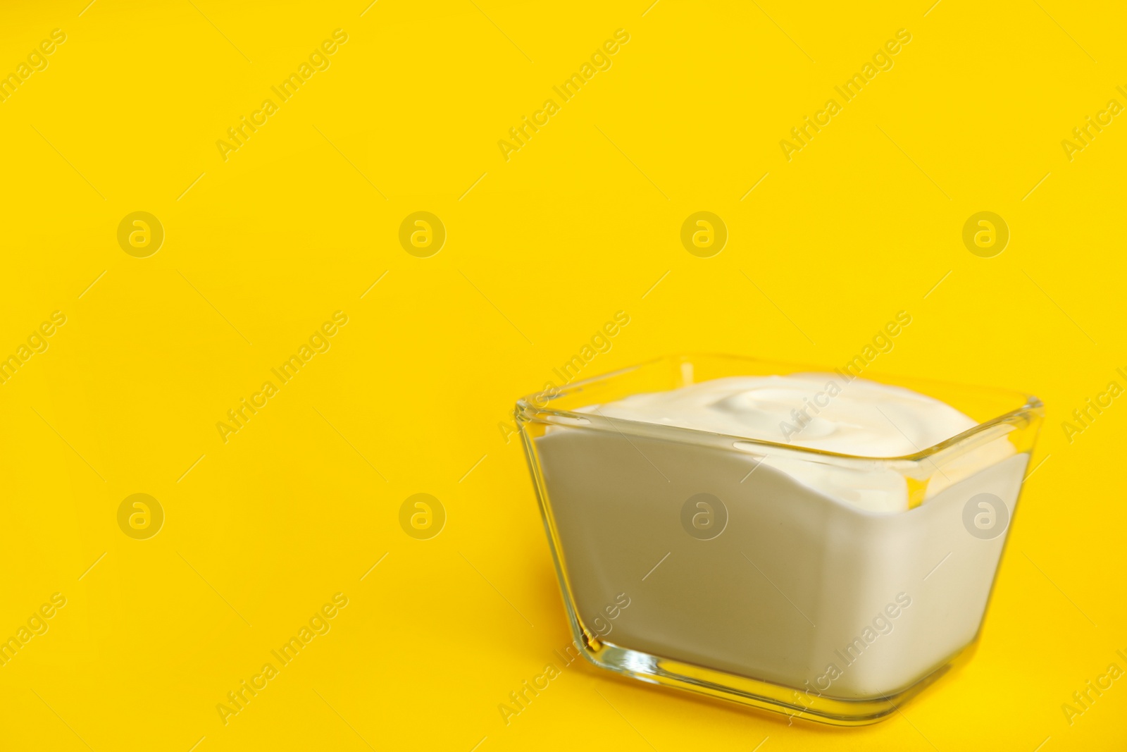 Photo of Tasty organic yogurt on yellow background. Space for text