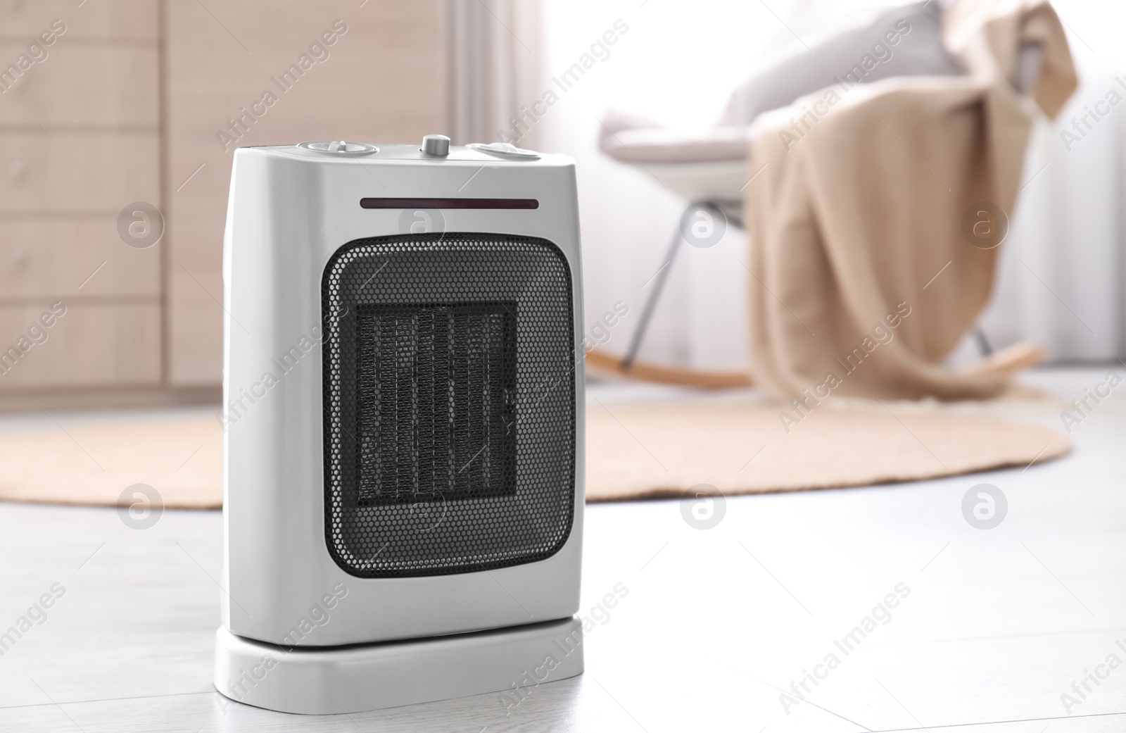 Photo of Modern electric fan heater on floor in room. Space for text