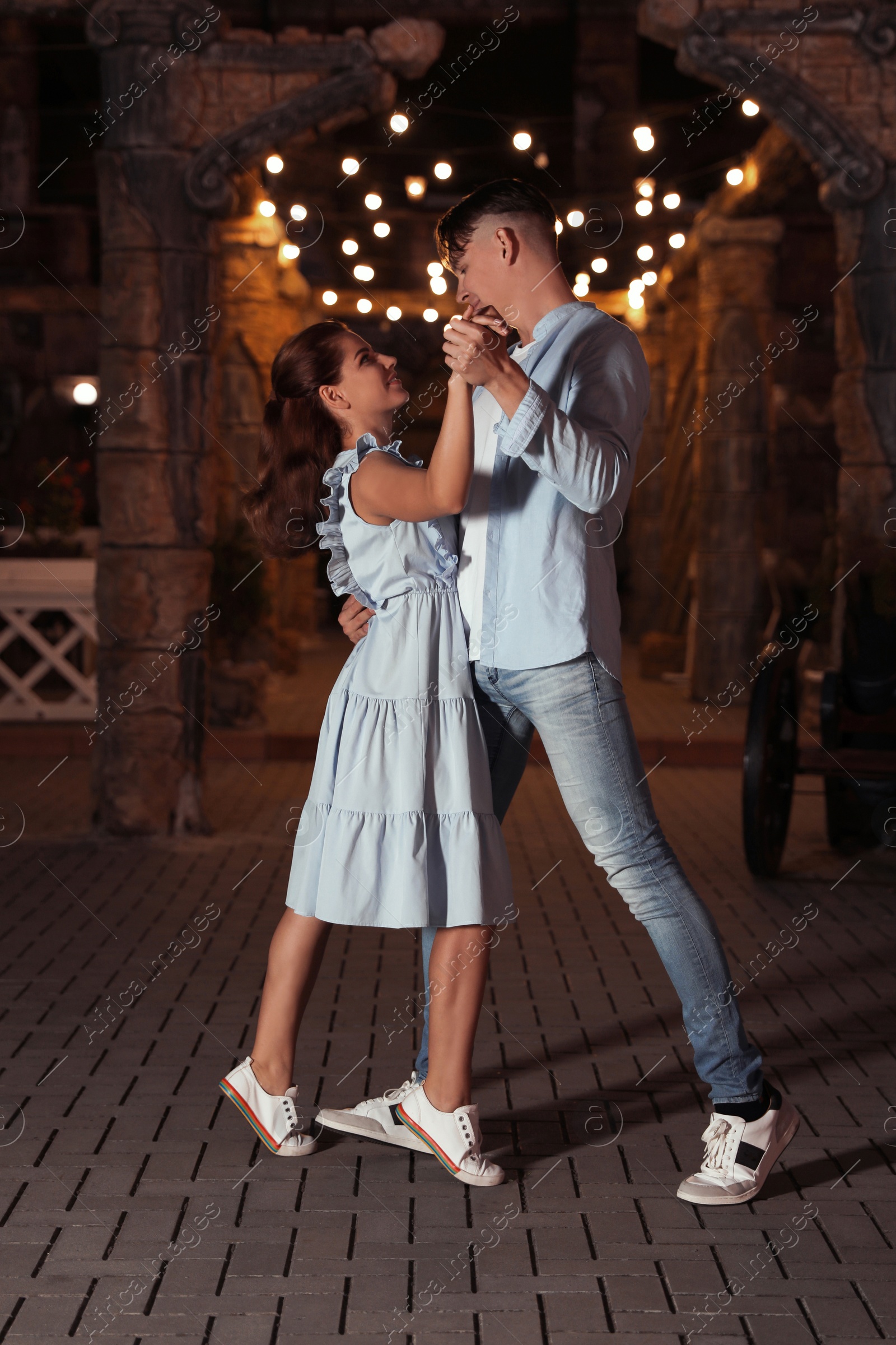 Photo of Beautiful young couple practicing dance moves in evening outdoors