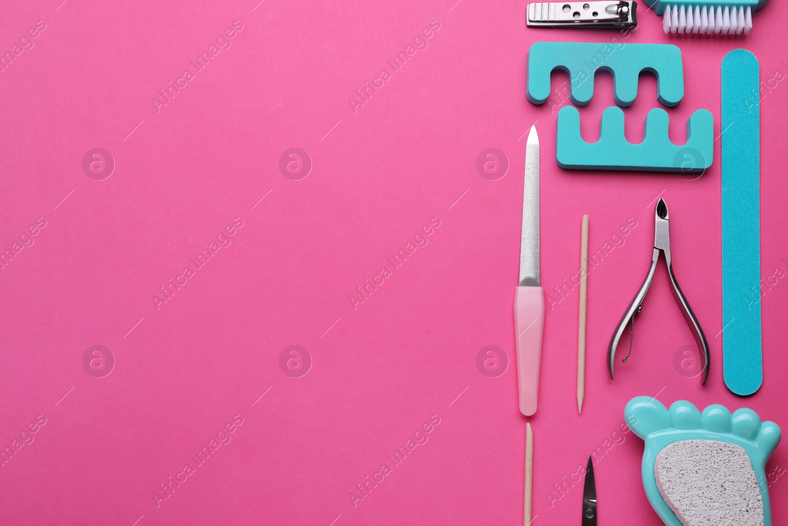 Photo of Set of pedicure tools on pink background, flat lay. Space for text