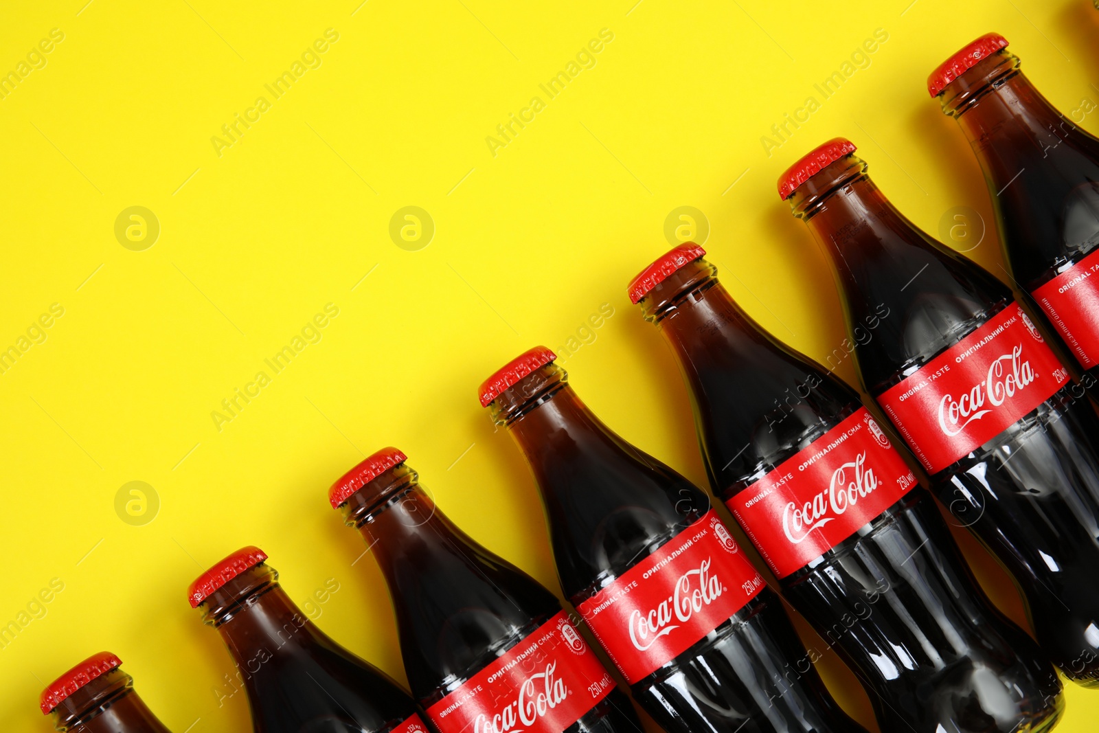 Photo of MYKOLAIV, UKRAINE - NOVEMBER 14, 2018: Bottles of Coca-Cola on color background, flat lay. Space for text