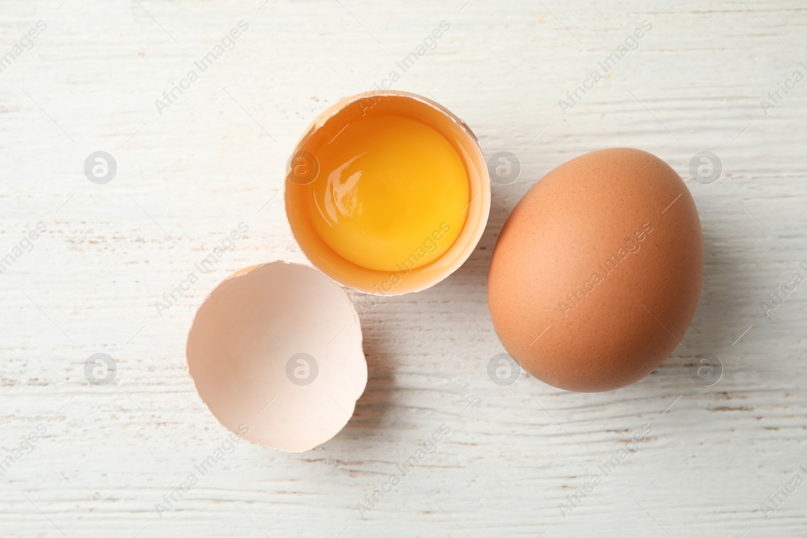 Photo of Raw chicken eggs on wooden background, top view