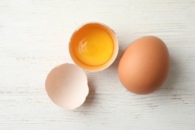 Photo of Raw chicken eggs on wooden background, top view