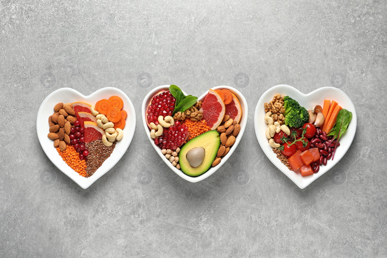 Photo of Plates with products for heart-healthy diet on grey background, top view