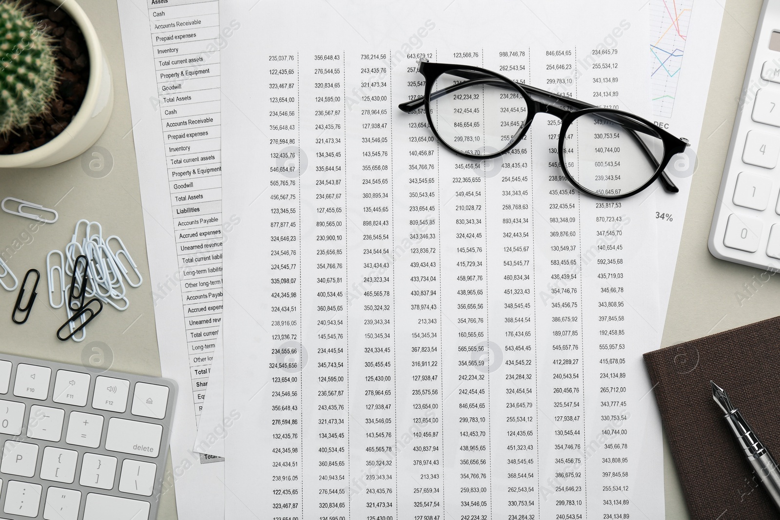 Photo of Accounting documents, glasses, computer keyboard and stationery on beige table, flat lay