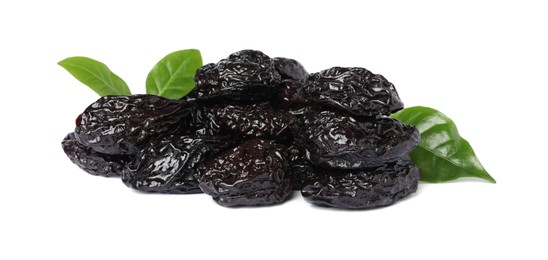 Heap of sweet dried prunes and green leaves on white background