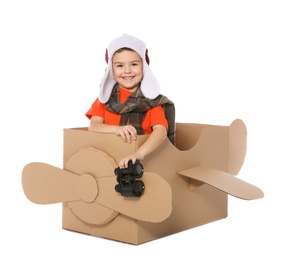 Photo of Cute little boy playing with binoculars and cardboard airplane on white background