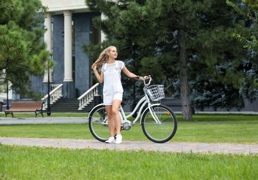 Beautiful woman in casual outfit with bicycle on city street