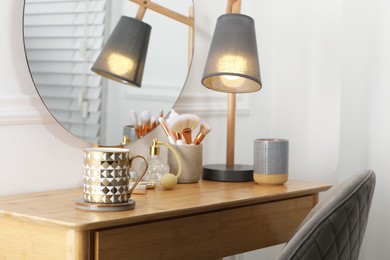 Mug of hot drink with stylish cup coaster on dressing table in room