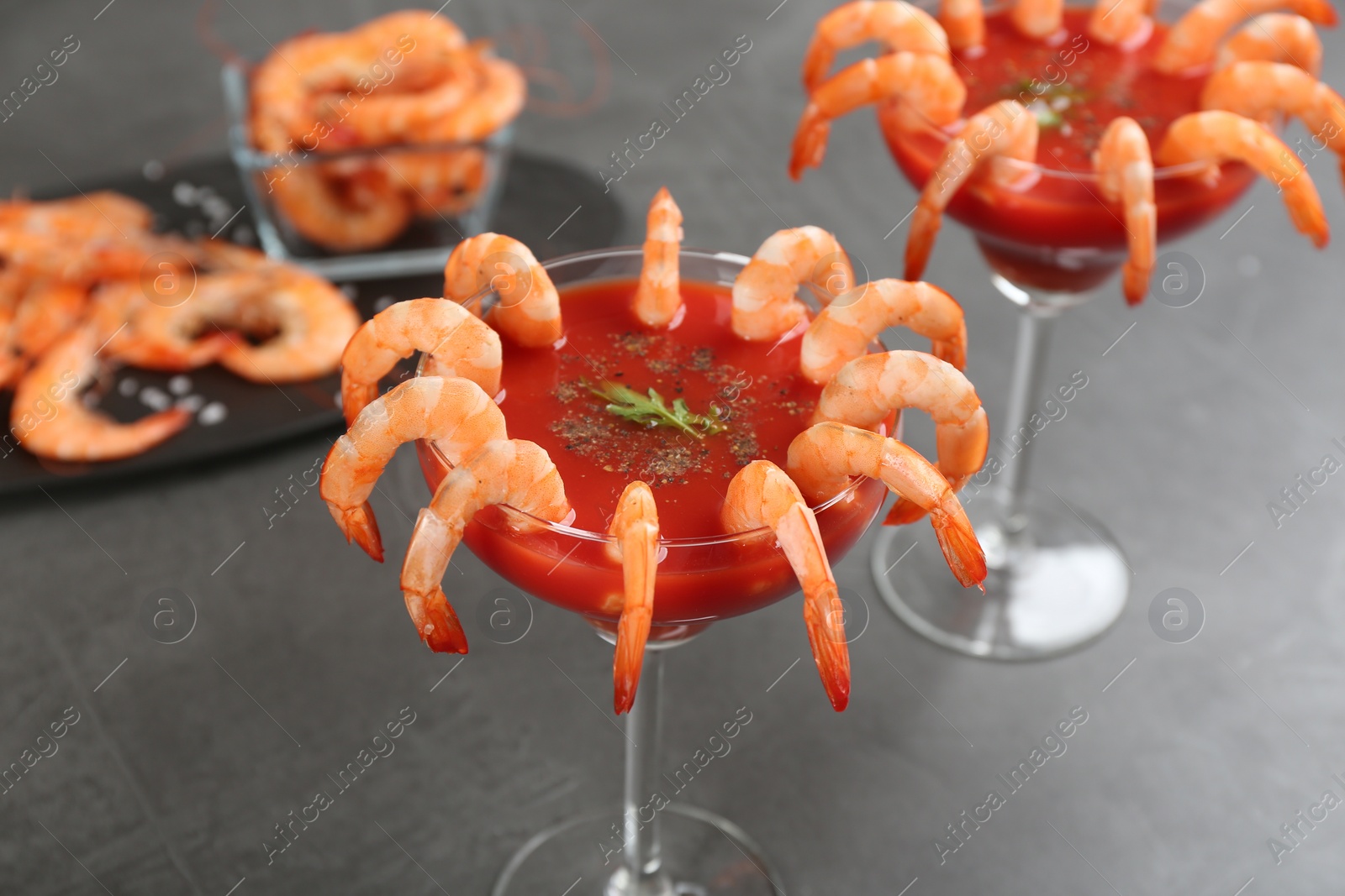 Photo of Delicious shrimp cocktail with tomato sauce on grey table