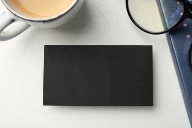 Photo of Blank black business card, cupcoffee, glasses and stationery on white table, top view. Mockup for design