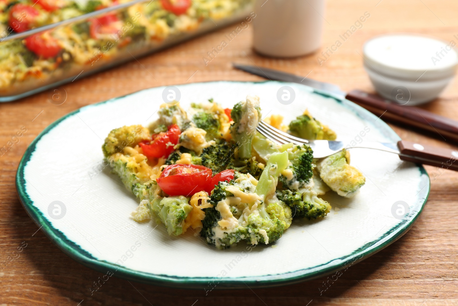 Photo of Tasty broccoli casserole served on wooden table