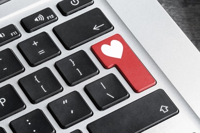 Love button on laptop keyboard, closeup. Online dating site