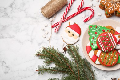 Flat lay composition with decorated Christmas cookies on white marble table. Space for text