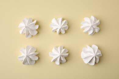 Delicious meringue cookies on beige background, flat lay