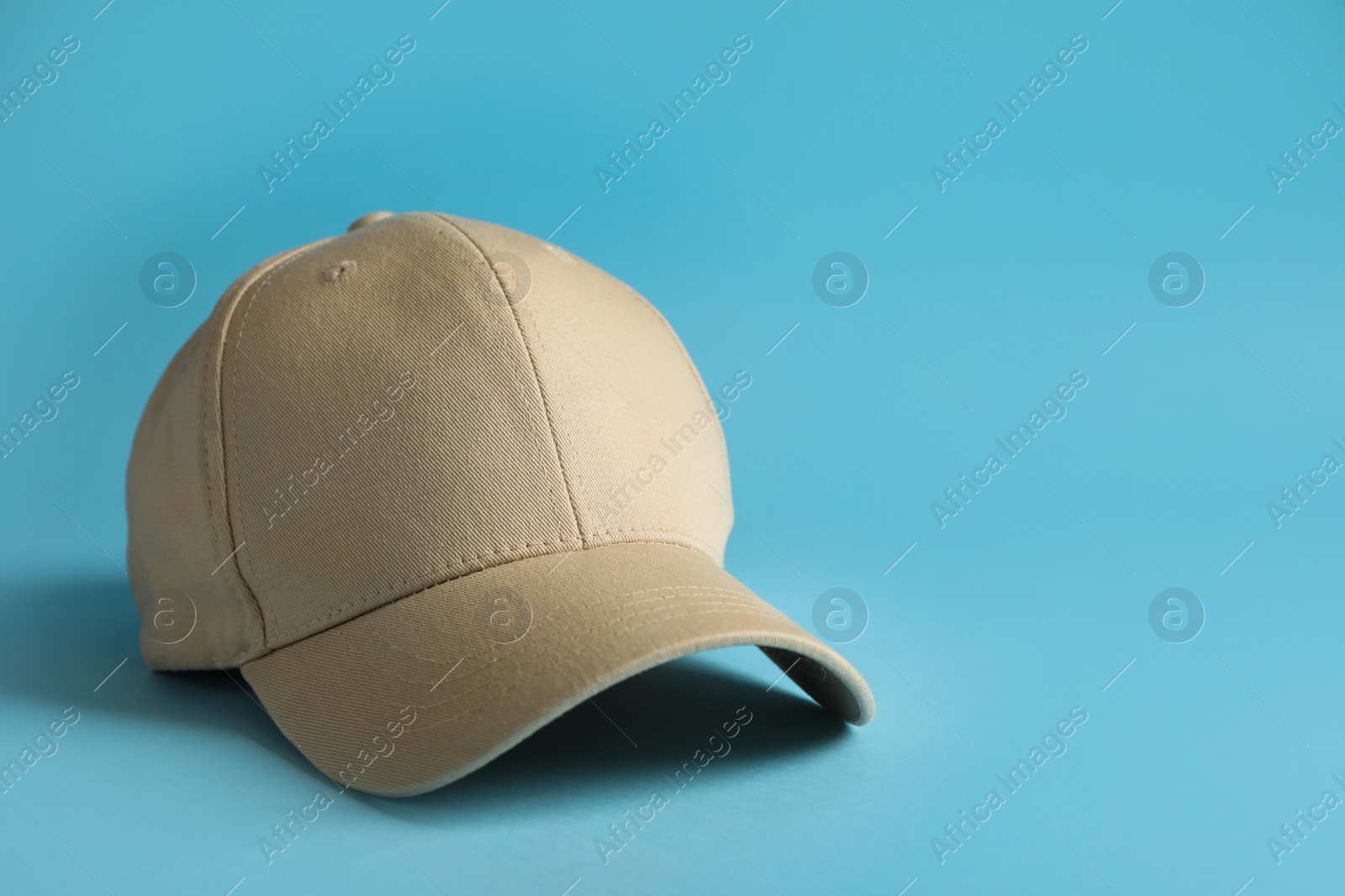 Photo of Baseball cap on light blue background, space for text