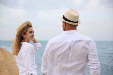 Happy couple having romantic walk on beach