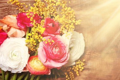 Image of Beautiful ranunculus and mimosa flowers on wooden background