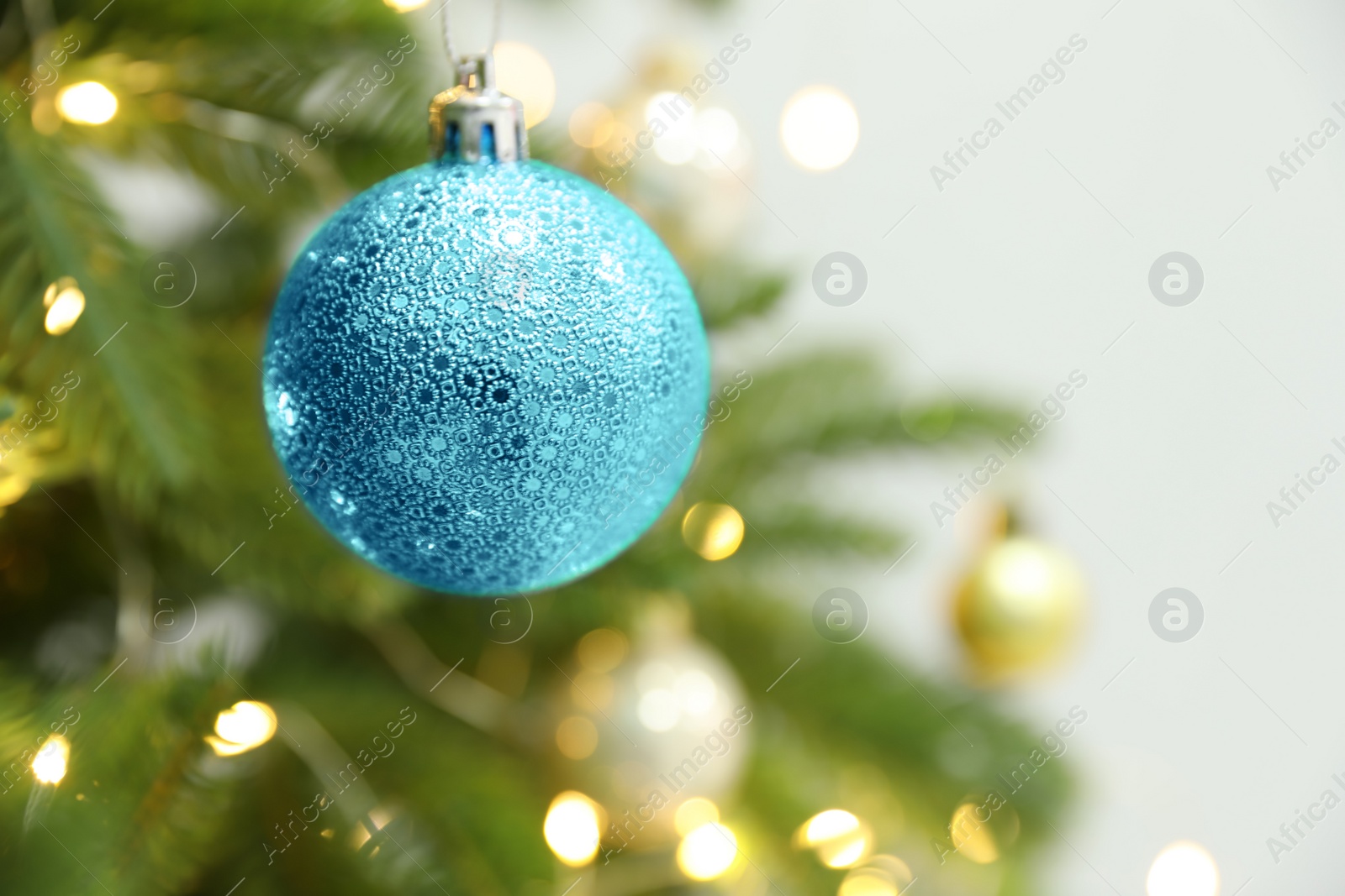 Photo of Beautiful holiday bauble hanging on Christmas tree, closeup. Space for text