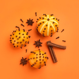 Photo of Flat lay composition with pomander balls made of fresh tangerines on orange background
