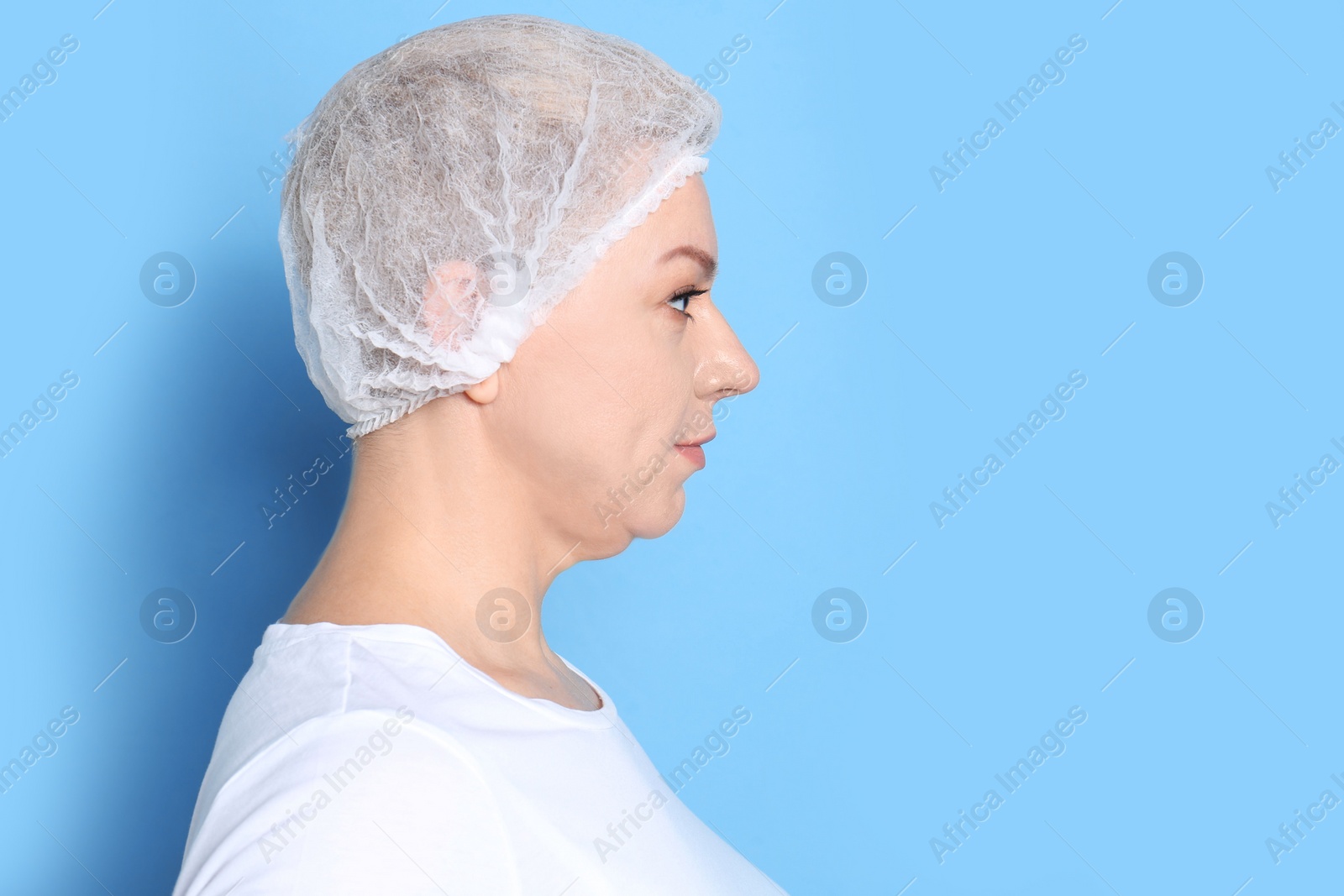 Photo of Mature woman with double chin on blue background. Space for text