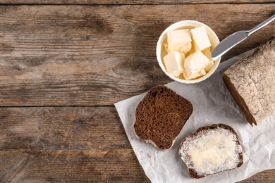 Photo of Flat lay composition with bread and butter on wooden table. Space for text