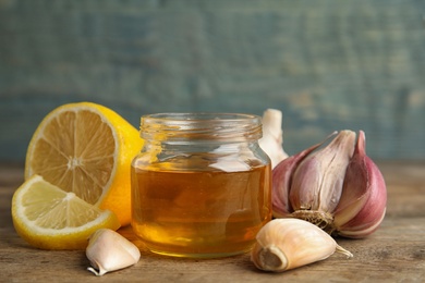 Composition with cold remedies on wooden table against blue background. Sore throat treatment