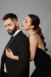 Photo of Handsome bearded man with sexy lady on grey background